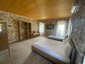 a bedroom with two beds and a stone wall at Myra in Himare