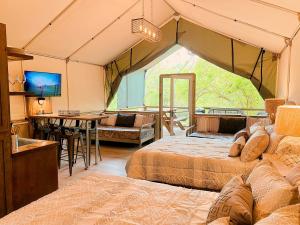 ein Zimmer mit 2 Betten, einer Küche und einem Esszimmer in der Unterkunft Beautiful Tented Cabin by a Creek - Ideal for a Fun Family Vacation in Seguin, Texas in Lauback