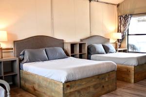 ein Schlafzimmer mit zwei Betten und einem Fenster in der Unterkunft Beautiful Tented Cabin by a Creek - Ideal for a Fun Family Vacation in Seguin, Texas in Lauback