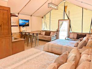 ein Schlafzimmer mit zwei Betten und ein Wohnzimmer in der Unterkunft Beautiful Tented Cabin by a Creek - Ideal for a Fun Family Vacation in Seguin, Texas in Lauback + 66 Fotos
