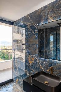 bagno con lavandino nero e finestra di Cuni Luxury Hotel a Sarandë Altre 37 foto