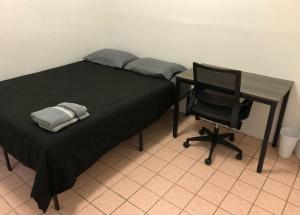 Private 2-bedroom apartment and New York City Manhattan only 15 mins away في يونيون سيتي: سرير مع مكتب وكرسي بجواره