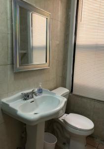 Private 2-bedroom apartment and New York City Manhattan only 15 mins away في يونيون سيتي: حمام مع حوض ومرحاض ومرآة