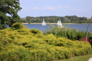 two sailboats on a lake with trees in the background at Family Lake House in Mikołajki
