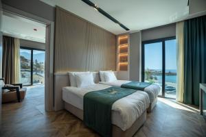 a bedroom with a large bed with a large window at Shayna Beach Club in Kérynia