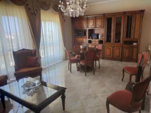 - un salon avec une table, des chaises et un lustre dans l'établissement A Casa di Sarina, à Riposto