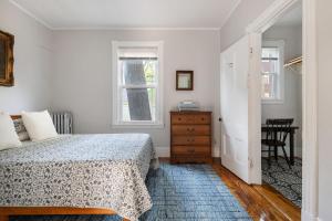 Un dormitorio con una cama y una cómoda y dos ventanas. en Knock on Wood - Airy Charm in Heart of Downtown, en Portland