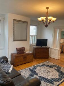 a living room with a couch and a television at Beautiful West End Apartment in Portland +14 photos