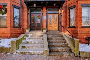 Un edificio de ladrillo con escaleras que conducen a una puerta. en State of Charm - Historic West End Haven, en Portland