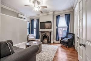 Una sala de estar con un sofá y una chimenea. en State of Charm - Historic West End Haven, en Portland