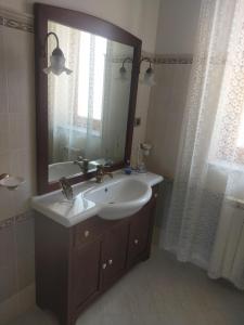 une salle de bain avec un lavabo et un miroir dans l'établissement A Casa di Sarina, à Riposto