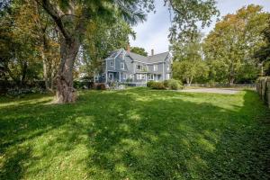 a large house with a tree in the yard at Back Cove - Large Sunny 2 Bedroom Condo in Portland