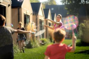 un gruppo di bambini che giocano con l'hula in un cortile di Pod Cyprysami - surf & family resort a Jastarnia