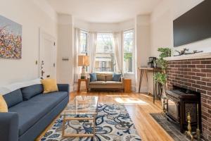 Una sala de estar con un sofá azul y una chimenea. en Local Landmark - Gorgeous Historic Home, en Portland