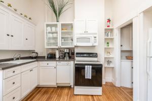 Una cocina con gabinetes blancos y un horno de estufa. en Local Landmark - Gorgeous Historic Home, en Portland 31 fotos más