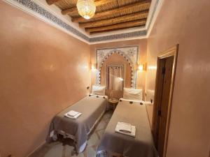 une chambre avec deux lits et un miroir dans l'établissement Riad Minami, à Marrakech