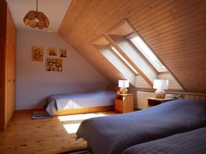 a attic bedroom with two beds and a window at Family Lake House in Mikołajki