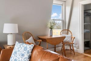 a living room with a couch and a table and a window at Skyline 138 Charming West End Mansard Penthouse in Portland