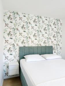 a bedroom with a bed and a wall with a floral wallpaper at Apartments Vinka in Jelsa