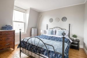 a bedroom with a bed and a dresser and a window at Skyline 138 Charming West End Mansard Penthouse in Portland
