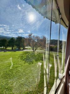 a window with a view of a field of grass at Pousada Cristal de Gelo in Urubici +26 photos
