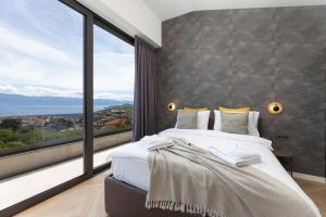 a bedroom with a large bed and a large window at Villa Panoramica with heated pool and sauna in Vrbnik +37 photos