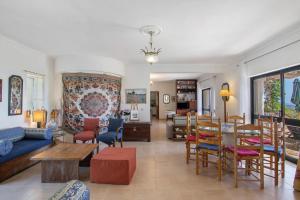 een woonkamer met een bank, een tafel en stoelen bij Villa La Ribeyre in Boliqueime