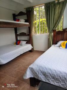 a bedroom with two bunk beds and a window at Trekkers haven Enjoy Colombia Ecoliving in Piedecuesta