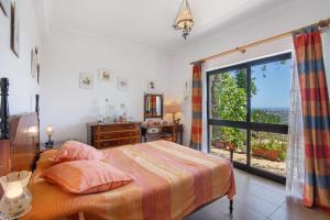 een slaapkamer met een bed en een groot raam bij Villa La Ribeyre in Boliqueime +28 foto's