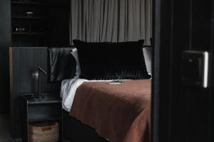 a bedroom with a bed with a black pillow at Silverback Lodge in Buhoma