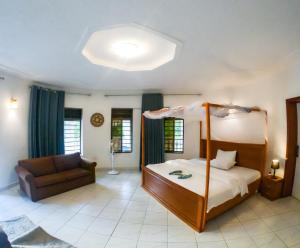 a bedroom with a canopy bed and a couch at Nature Kigali in Kigali