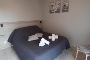 a bedroom with a blue bed with two rolled towels at Gîtes plouraboué "Lou Chai" in Navailles-Angos