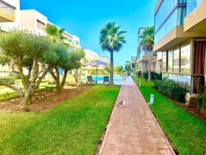 a dog walking down a sidewalk next to a building at Sidi rahal Blue beach in Sidi Rahal