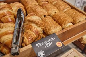 a bunch of croissants in a display case in a bakery at Appart'hôtel Odalys City - Bioparc Lyon Est in Lyon