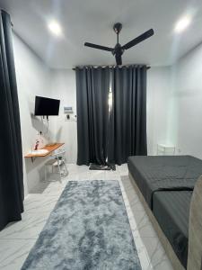 a bedroom with a bed and a ceiling fan at Dtamu Mama Roomstay w Pool and Wifi in Kertih +5 photos
