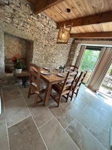 a dining room with a wooden table and chairs at Gîtes sur Le Causse de St CHELS, charme sport et détente in Saint-Chels