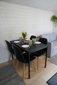 a black table and chairs in a living room at Seaside cottage with private beach & wood-fired sauna in Vörå, Finland in Oravais