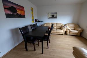 a dining room with a table and chairs and a couch at Grund í Grundarfirði Economy Guesthouse in Grundarfjordur +42 photos
