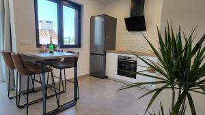 a kitchen with a table and a refrigerator and a plant at Villa Emma - luksuzna kuća s bazenom Wellness & SPA in Ražanac