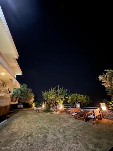 a group of picnic tables in a yard at night at Filoxenia Residence in Palasë