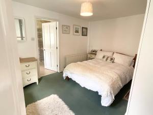 ein Schlafzimmer mit einem weißen Bett und einem weißen Teppich in der Unterkunft Lorash Cottage, Ashbourne in Ashbourne