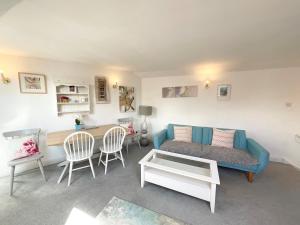 ein Wohnzimmer mit einem blauen Sofa und einem Tisch in der Unterkunft Lorash Cottage, Ashbourne in Ashbourne
