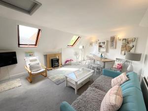 ein Wohnzimmer mit einem blauen Sofa und einem Tisch in der Unterkunft Lorash Cottage, Ashbourne in Ashbourne