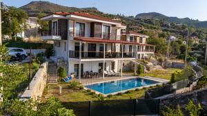 a house on a hill with a swimming pool at Villa Nirvana Selimiye Daily Weekly Rentals in Marmaris