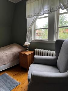 a bedroom with a bed and a chair and a window at Luthagård in Äng