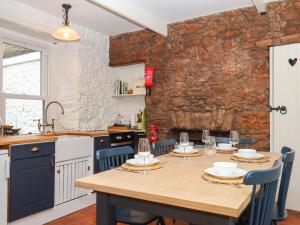 une cuisine avec une table en bois et des chaises bleues dans l'établissement Captains Cottage, à Brixham