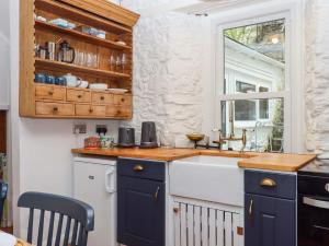 une cuisine avec un évier et une fenêtre dans l'établissement Captains Cottage, à Brixham 35 autres photos