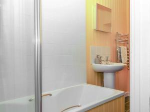 une salle de bain avec une baignoire, un lavabo et une douche dans l'établissement Captains Cottage, à Brixham