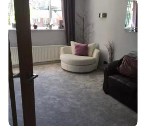 a living room with a white chair and a couch at Commuters Haven perfect for conferences airport and offices near airport in Cove +1 photo