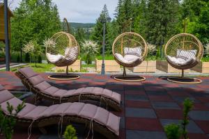 three wicker chairs sitting on a patio at Glamp Mała Łąka Jacuzzi & Sauna Zakopane in Zakopane